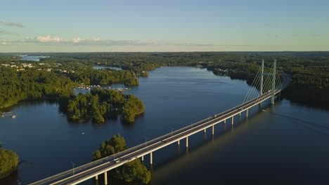 Long-bridge-over-a-lake-in-Heinola,-Finland,-revealing-Nordic-landscape,-houses,-cars