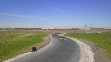 Green-racing-car-drifting-on-a-track-with-smoking-tires-and-skid-marks-on-an-asphalt