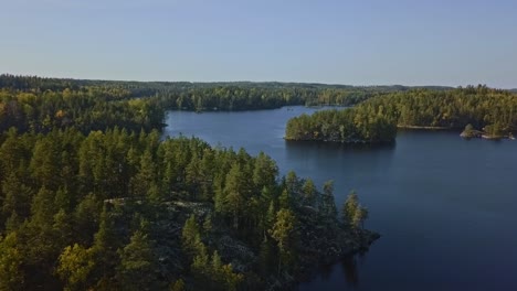 Epic-shot-of-a-nordic-forest-in-Finland,-national-park-with-islands-and-forest,-stone-shores-and-deep-blue-water