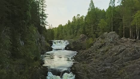 Aerial-footage-of-a-Karelian-waterfall-Kivach,-full-water-flow-over-the-top