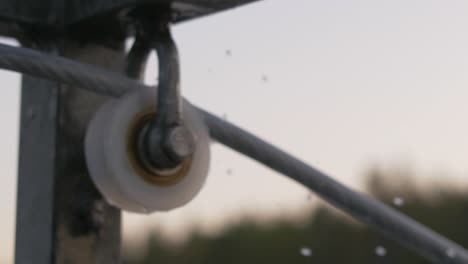 Close-up-blurry-mechanism-of-a-rotating-spinning-wheel-with-slow-motion-water-drops-falling