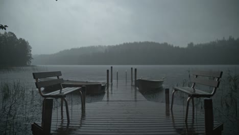Moody-storm,-rain-and-thunder-in-a-lake-forest-with-boats,-pierce-and-benches,-4K