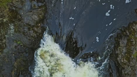 Aerial-footage-of-a-Karelian-waterfall-Kivach,-full-water-stream-over-the-top,-beautiful-nature,-foam-on-water