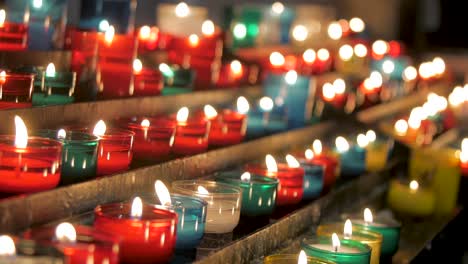 Colorful-candles-burning-in-church,-religious-prayers-symbolism