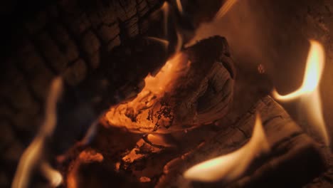 Fire-in-a-fireplace-in-slow-motion-with-pieces-of-wood-through-a-tiled-grill