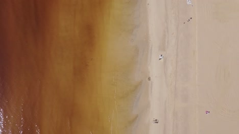 Beach-aerial-top-down-view-with-a-few-people-on-the-shore