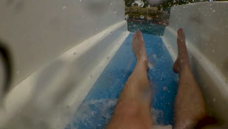 First-Person-Shot-of-A-Man-Going-Down-a-Water-Park-Slide-Before-Plunging-Underwater