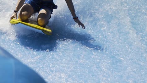 Boy-riding-wave-machine-on-boogie-board-slow-motion