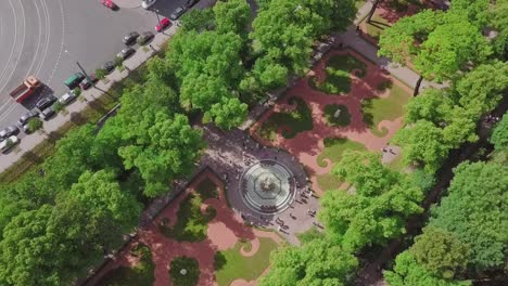 Summer-Garden,-an-aerial-drone-fly-by-of-a-beautiful-Koronniy-fountain-from-top,-people-visiting-the-festival,-with-flowers-and-summer-feeling,-historic-park