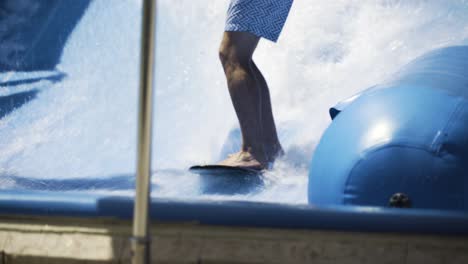 Close-up-on-man's-feet-as-he-struggles-to-balance-while-surfing-a-wave-machine