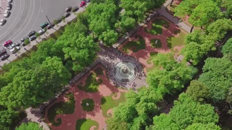 Summer-Garden,-an-aerial-drone-fly-by-of-a-beautiful-Koronniy-fountain-from-top,-people-visiting-the-festival,-with-flowers-and-summer-feeling,-historic-park