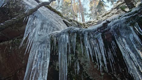 Huge-icicle-over-a-rocky-mountain-in-winter-forest