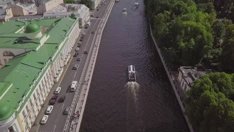 Saint-Petersburg,-an-aerial-drone-footage-of-a-boat-in-a-river,-channel,-Church-of-Savior-on-Blood,-Castle,-center-of-Saint-Petersburg,-overview-shot-on-the-city-in-summer,-cars-driving-by-the-river