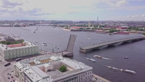 Saint-Petersburg,-an-aerial-drone-footage-of-an-open-bridge-in-Neva-river,-boats-in-a-river,-channel,-center-of-Saint-Petersburg,-cars-driving-by-the-river,-Peter-and-Paul-Fortress
