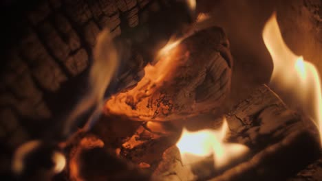 Fire-in-a-fireplace-in-slow-motion-with-pieces-of-wood-through-a-tiled-grill