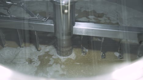 Churning-barley-grain-in-brewery-silo-for-beer-production,-CLOSE-UP