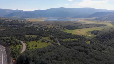 Aufsteigende-Luftaufnahme-Eines-Grünen-Tals-Mit-Feldern-Und-Wasser