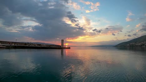 Wolken,-Die-Im-Warmen-Sonnenuntergang-über-Einem-Kurzen-Leuchtturm-In-Der-Bucht-Von-Senj,-Kroatien,-Hetzen