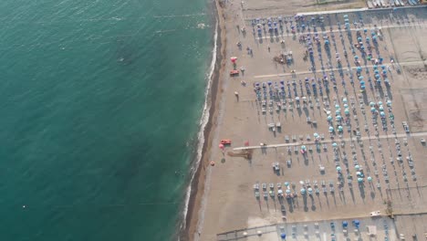 Bird's-eye-view-of-a-sandy-beach-with-sunbeds-and-umbrellas