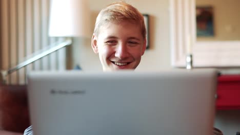 Glücklich-Lächelnder-Teenager,-Der-Auf-Etwas-Auf-Dem-Laptopbildschirm-Reagiert