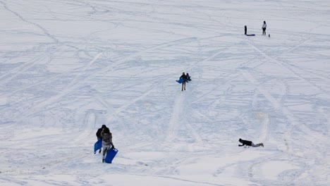 People-tobogganing-during-the-winter-down-a-hill