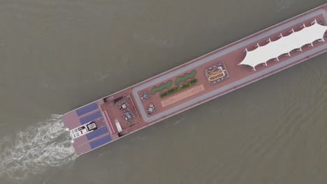 Ascending-aerial-view-of-the-back-of-a-long-boat-in-the-river
