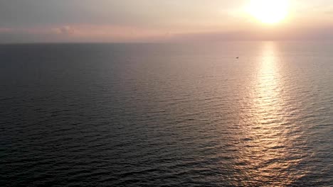 Turning-aerial-view-of-a-sunset-over-the-sea