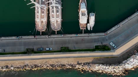 Vertical-point-of-view-of-four-boats-docked-by-a-concrete-pier