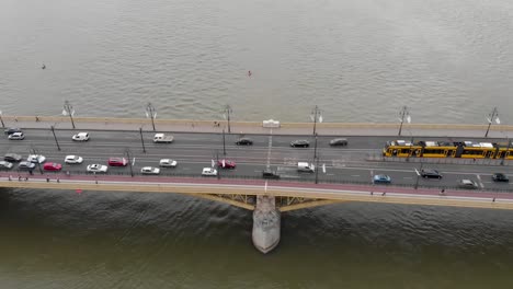 Aerial-view-of-a-bridge-over-the-river-with-heavy-traffic-and-yellow-trams