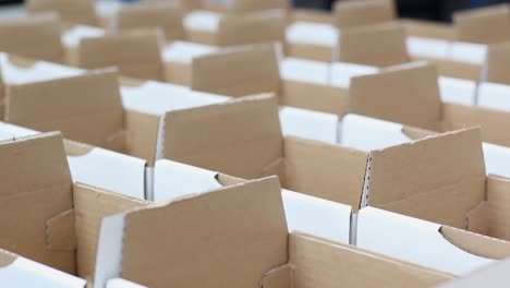 Many-rows-of-small-white-boxes-sit-in-a-packaging-warehouse
