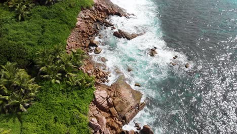 Aerial-view-of-waves-breaking-at-the-unpeopled-coastline-at-Anse-Songe-on-La-Digue,-an-island-of-the-Seychelles