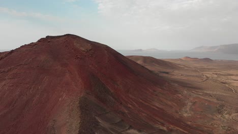 Luftaufnahme-Einer-Roten-Vulkanlandschaft-Am-Meer