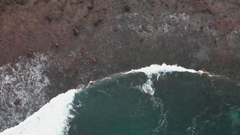 Luftaufnahmen-Von-Drohnen-Von-Meereswellen,-Die-Die-Vulkanische-Küste-Spülen