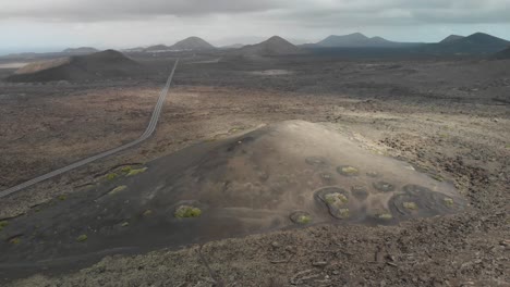 Aerial-view-of-a-road-crossing-through-a-volcanic-landscape