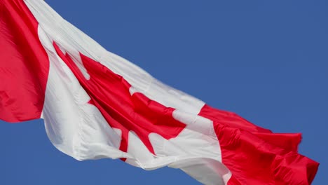 4K---Canadian-Flag-blowing-in-the-wind,-on-a-clear-sunny-day