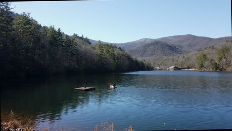man-fishing-on-small-lake-in-a-kayak