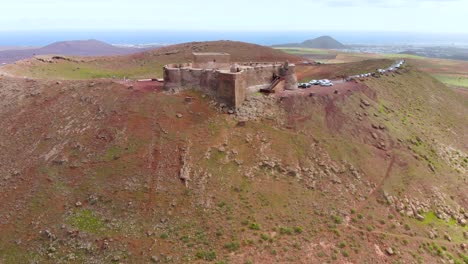 Flying-over-a-volcano-with-an-old-castle-on-its-rim