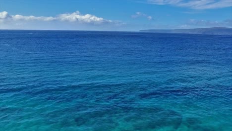 Panning-aerial-shot-of-a-snorkeler-in-Maui-Hawaii-in-beautiful-with-blue-water,-sand-and-coastline