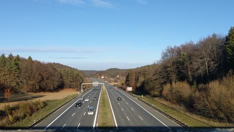Blick-Von-Einer-Brücke-Hinunter-Auf-Die-Deutsche-Autobahn-Mit-Vielen-Vorbeifahrenden-Autos