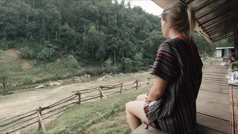 Female-tourist-looking-out-over-jungle-valley-in-an-elephant-sanctuary