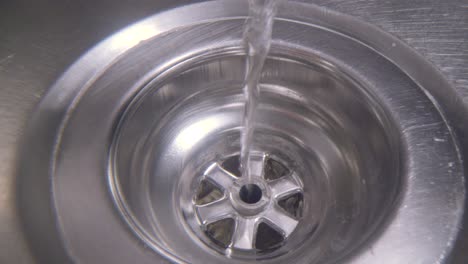 Water-vortex-shot-underwater-extreme-macro-close-up-of-a-laundry-sink-plug-hole-as-water-empties-with-a-thin-jumpy-vortex-that-forms-above-the-lens