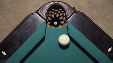 Overhead-view-of-player-sinking-the-black-8-ball-and-winning-a-game-of-billiards