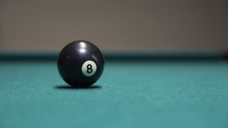Black-8-ball-spinning-to-a-stop-on-a-billiards-table
