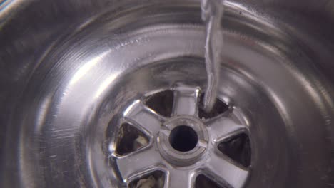 Water-vortex-shot-underwater-extreme-macro-close-up-of-a-laundry-sink-plug-hole-as-water-empties-with-a-large-vortex-that-forms-above-the-lens