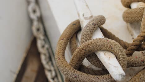 Closeup-shot-of-a-rope-wrapped-around-a-cleat-on-a-sailboat-deck