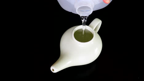 Neti-pot-being-filled-with-distilled-water