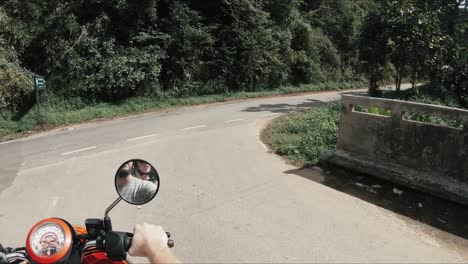 Couple-riding-a-moped-through-beautiful-mountainous-road-in-Thailand