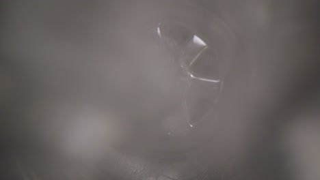 Water-vortex-shot-underwater-extreme-macro-close-up-of-a-laundry-sink-plug-hole-as-water-empties-with-a-large-vortex-that-forms-around-the-lens