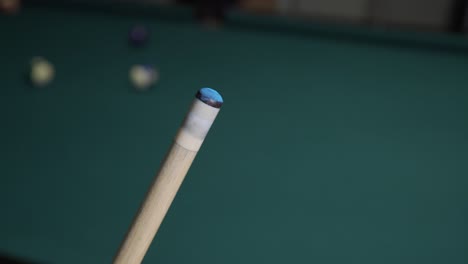 Player-chalking-pool-cue-during-billiards-game