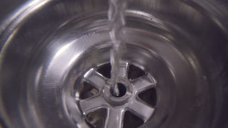 Water-vortex-shot-underwater-extreme-macro-close-up-of-a-laundry-sink-plug-hole-as-water-empties-with-a-jumpy-thin-vortex-that-forms-above-the-lens